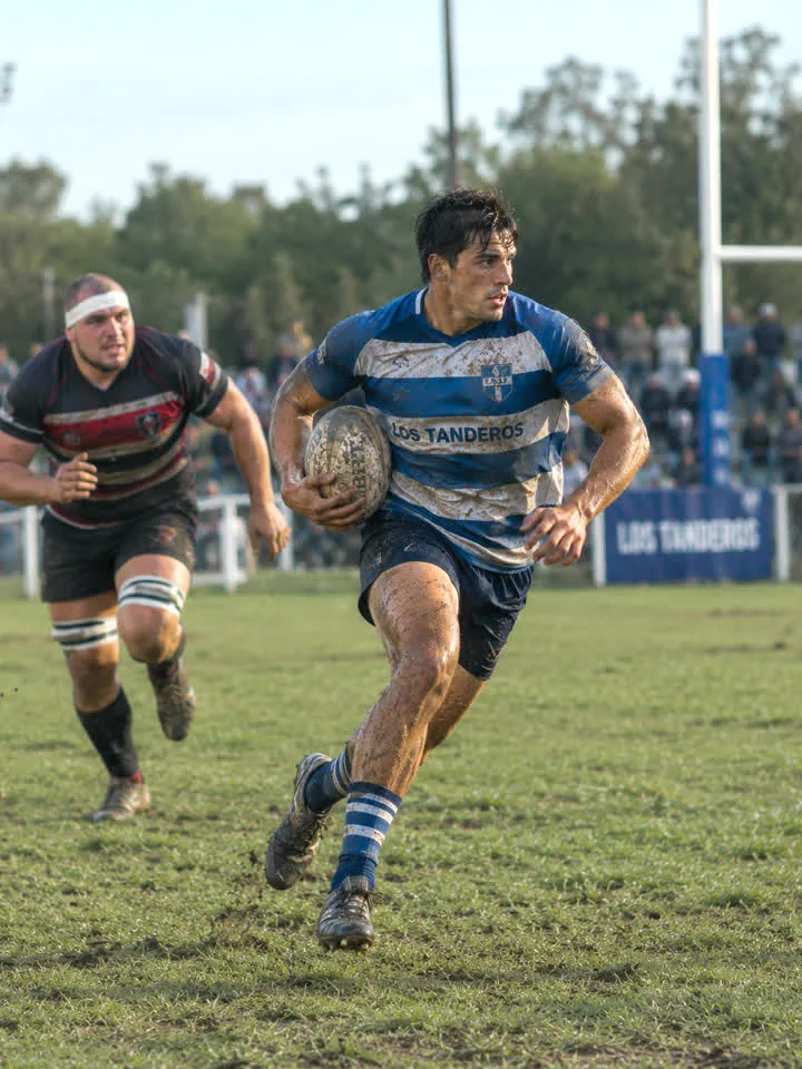 Rugbier joven corriendo con la pelota